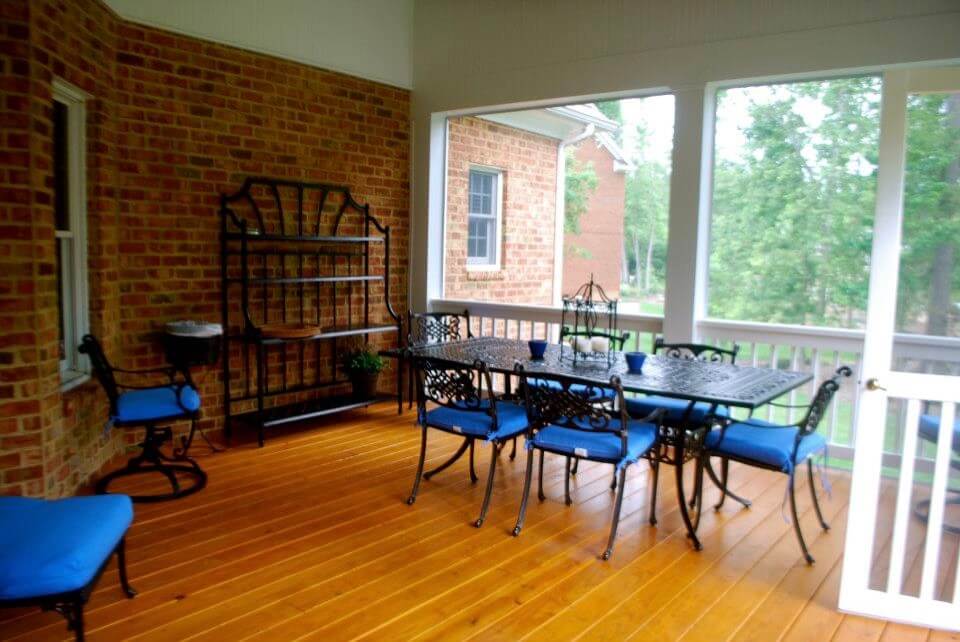 Covered and screened deck with black outdoor dining table and chairs, stained by HPI